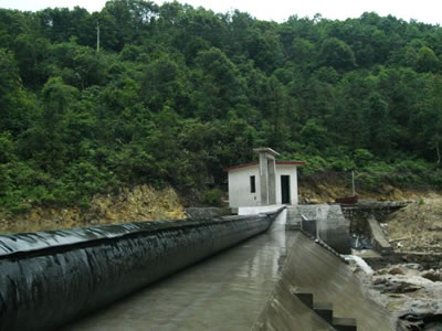 A black bookend rubber dam is wet on the concrete slope.