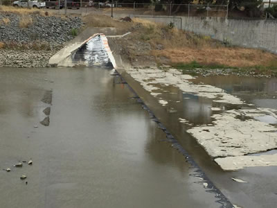Complete collapsed water inflatable rubber dam is in the water.
