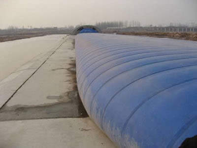 Dark blue air inflatable rubber dam is wide with many vertical grains.