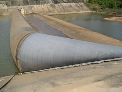 Inclined air inflatable rubber dam used for one period has sludge on the dam bag.