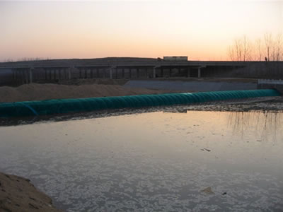 A blue water inflatable rubber dam retain water in one side.