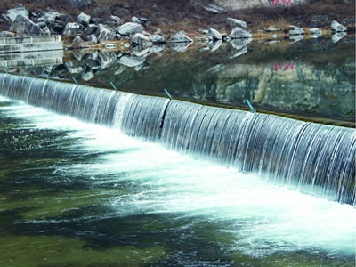 Upstream water flowing through shield type rubber dam forms water curtain.