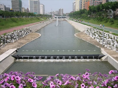 Spoiler rubber dam is in the water and the river shore is made of stone.